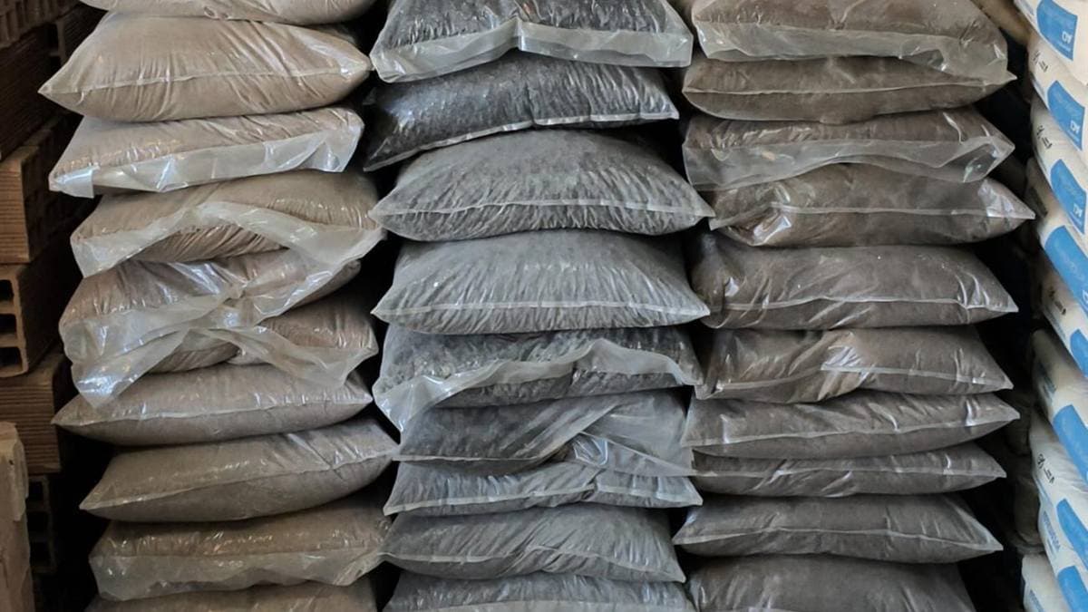 Sacos de areia e brita ensacadas empilhados em palete no depósito da Progresso Materiais de Construção em Aparecida de Goiânia